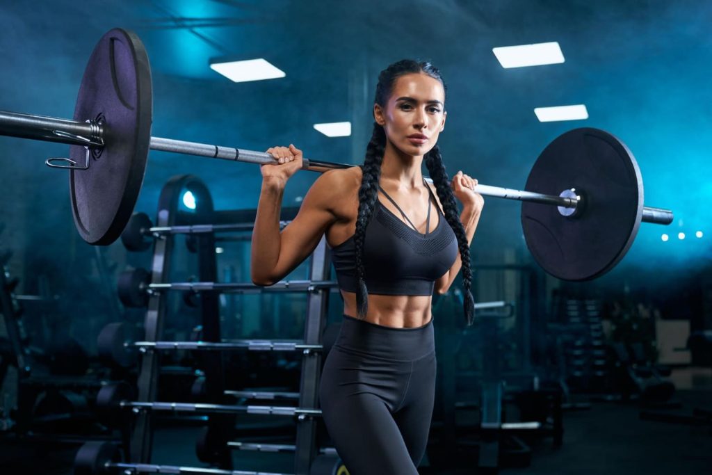 woman-holding-barbell-shoulders-gym