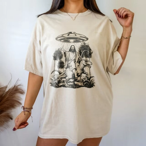 Jesus Riding Dinosaur UFO Tee – Quirky Sci-Fi Inspired T-Shirt – Unique Fantasy Graphic Tee