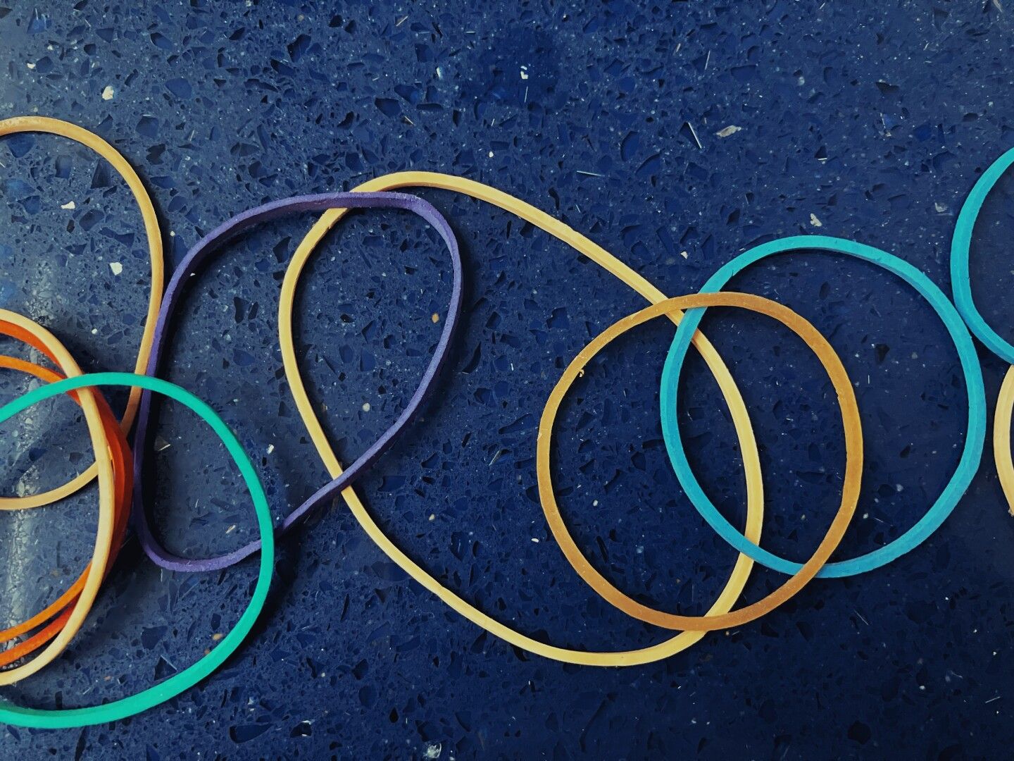 Unas gomas de colores sobre un fondo de piedra azul.